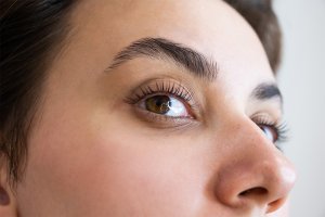 Close-up view of a woman's eye and brows, highlighting natural eyelashes that have been treated with a lash lift.