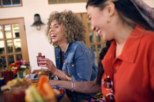 Two women are smiling with smooth, glowing skin.